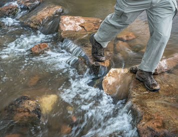 Walking across waterfall stream